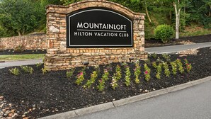 A stone sign with 'MOUNTAINLOFT' and 'HILTON VACATION CLUB' written on it.