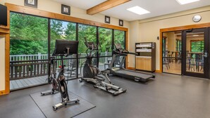 A gym with stationary bikes, treadmills, and a weight bench.