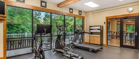 Un gimnasio con bicicletas estáticas, cintas de correr y un banco de pesas.