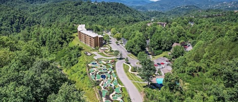 Campo de golf con un edificio y aparcamiento.