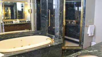 A luxurious bathroom with a large bathtub, a separate sink, and a glass-enclosed shower.