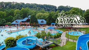 A water park with multiple swimming pools, slides, and a covered area with buildings. - General Morgan Inn (Greeneville)