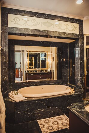 A luxurious bathroom with a large marble sink, a freestanding bathtub, and a mirror above the sink.