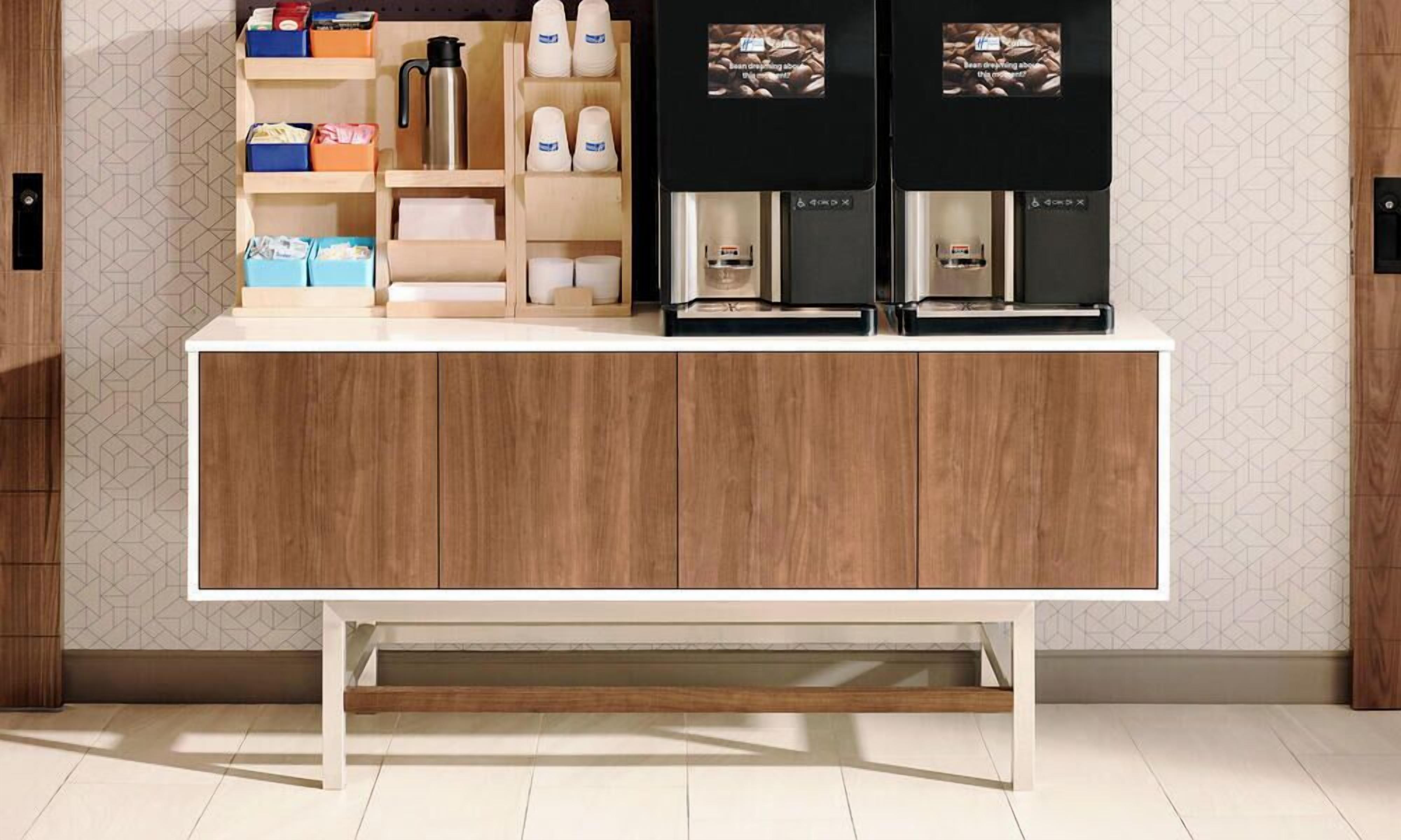 A kitchen with a wooden cabinet, a coffee machine, and various kitchen items.