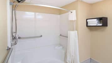 A walk-in shower with a handheld showerhead, grab bars, and a towel rack.