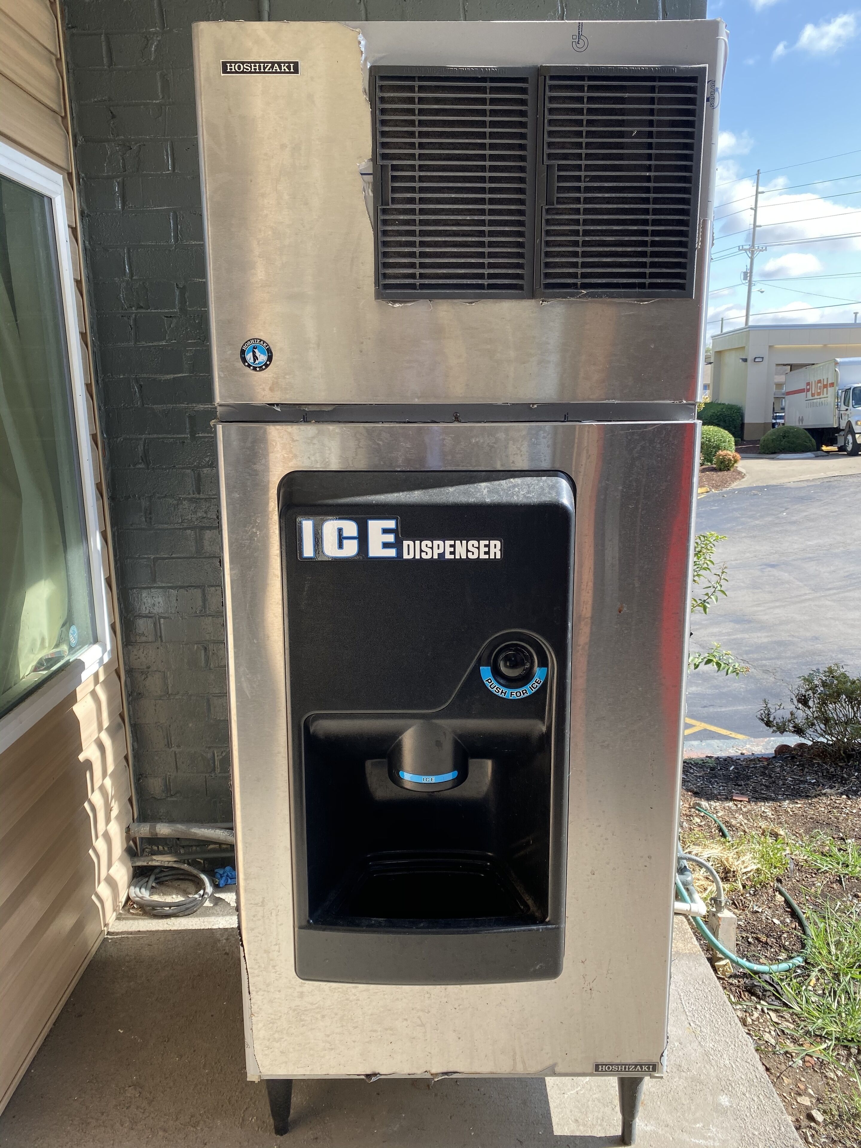 Un distributeur de glaçons en acier inoxydable, doté d’un bouton-poussoir et d’une étiquette indiquant « DISTRIBUTEUR DE GLACONS ».