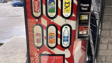 Máquina expendedora de Coca-Cola con diversas opciones de bebidas e interfaz de pago.