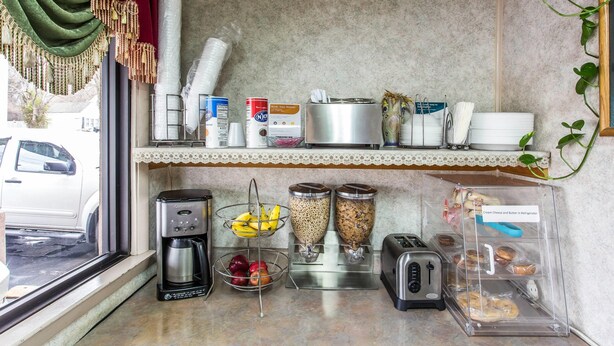 Eine Küchenzeile mit Kaffeemaschine, Obstschale, zwei Müslidosen, einem Toaster und einem Kühlschrank mit Etikett.