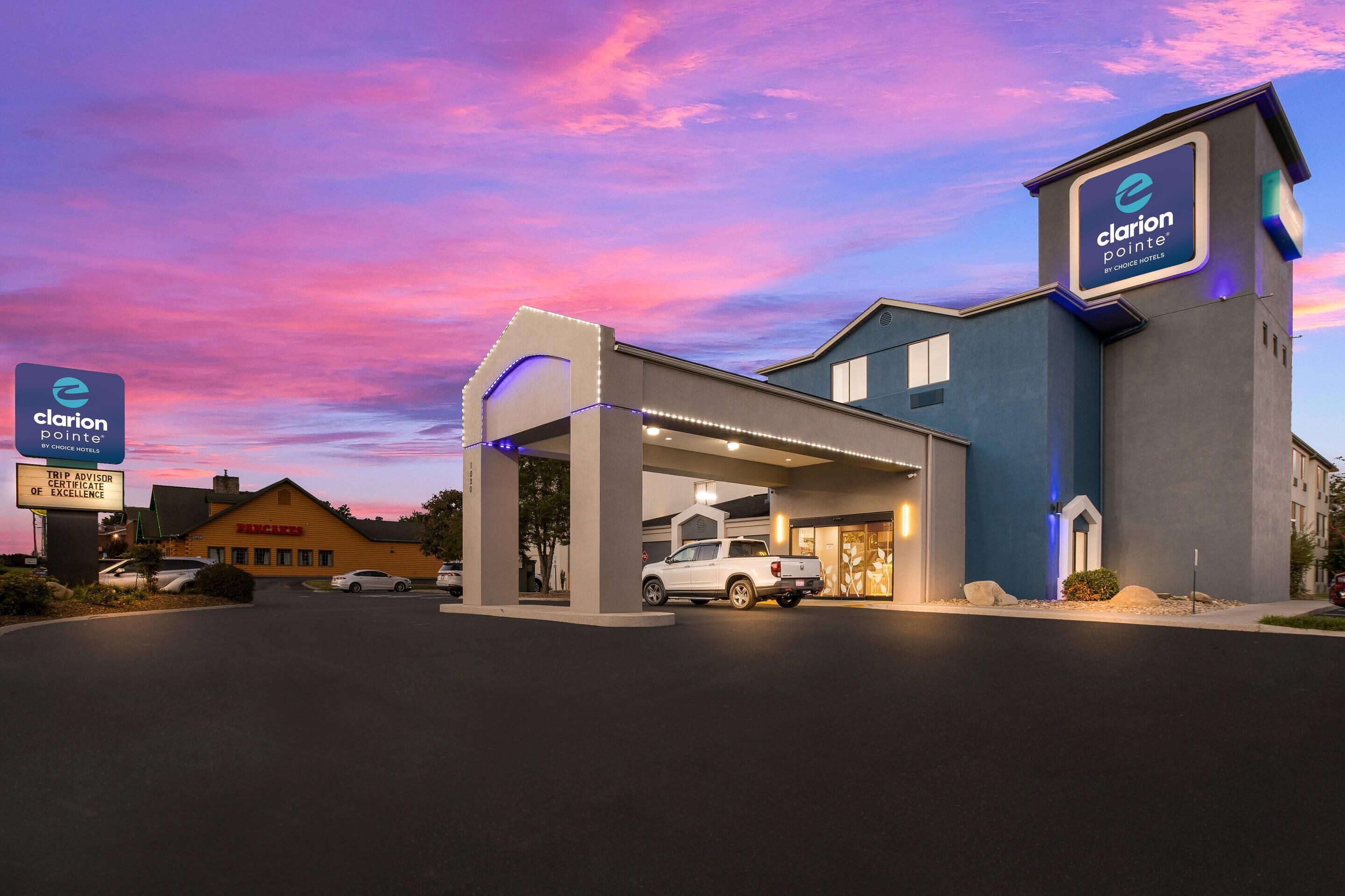 Ein Clarion Pointe Hotel von Choice Hotels mit modernem Design, einem überdachten Eingang und einem Parkplatz.