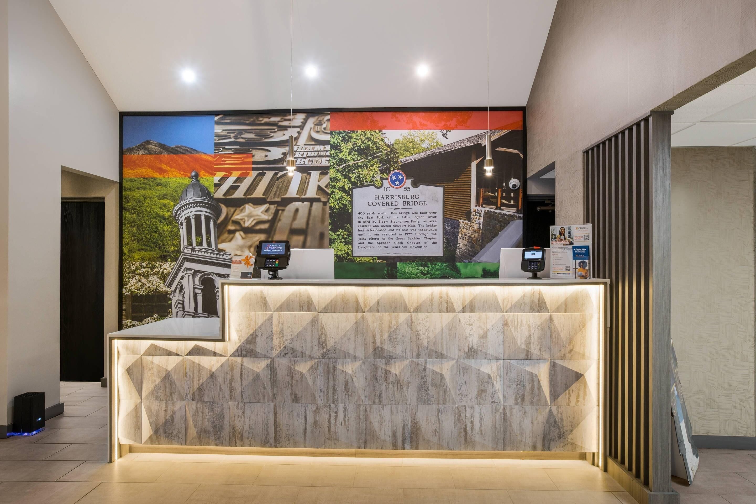 A reception desk with a digital kiosk, a large informational poster, and a modern reception area.