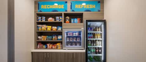 Un área de venta con aperitivos y bebidas, con la etiqueta 'RECHARGE' y 'REFRESH'.