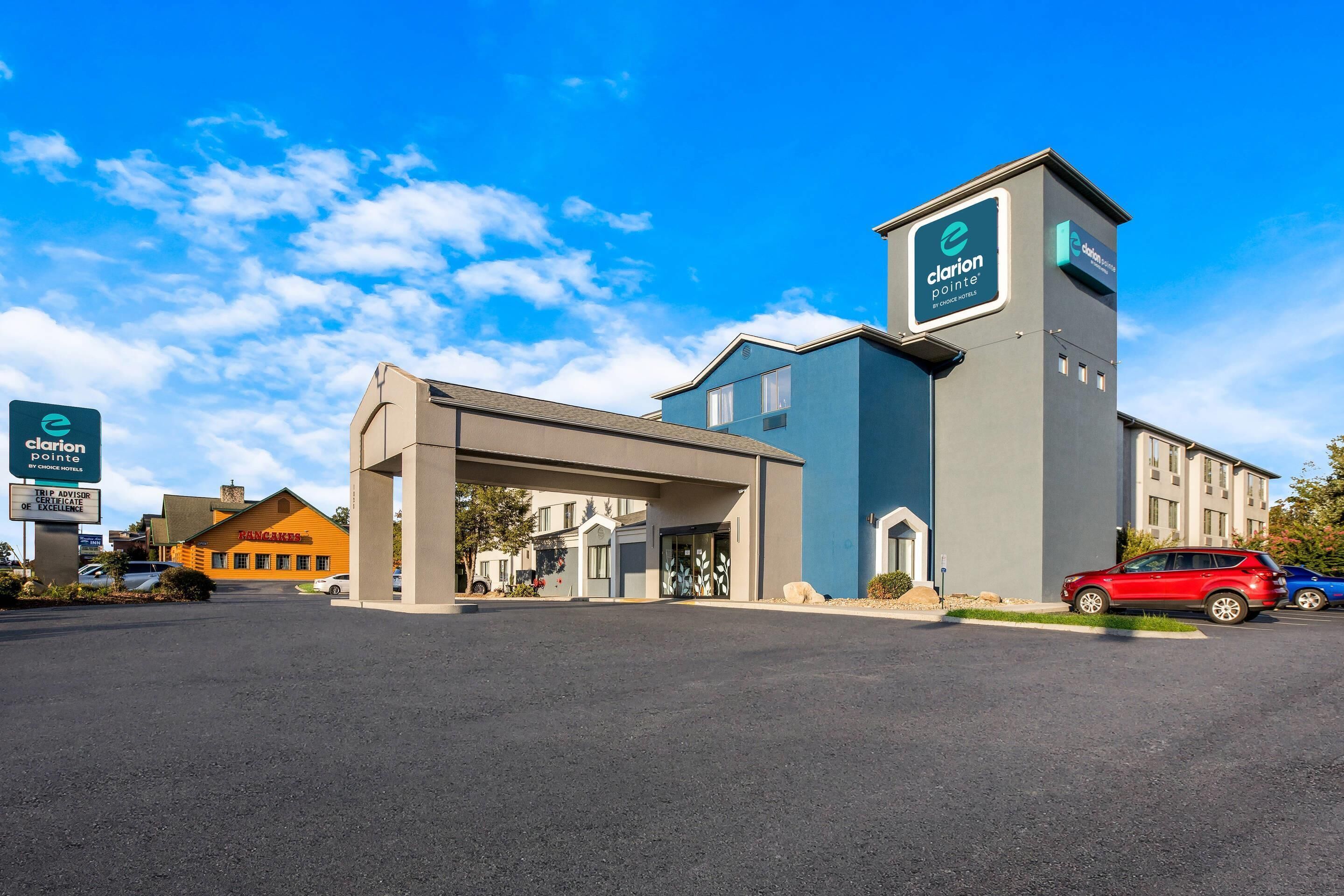 A hotel with a modern design, featuring a prominent tower and a covered entrance.