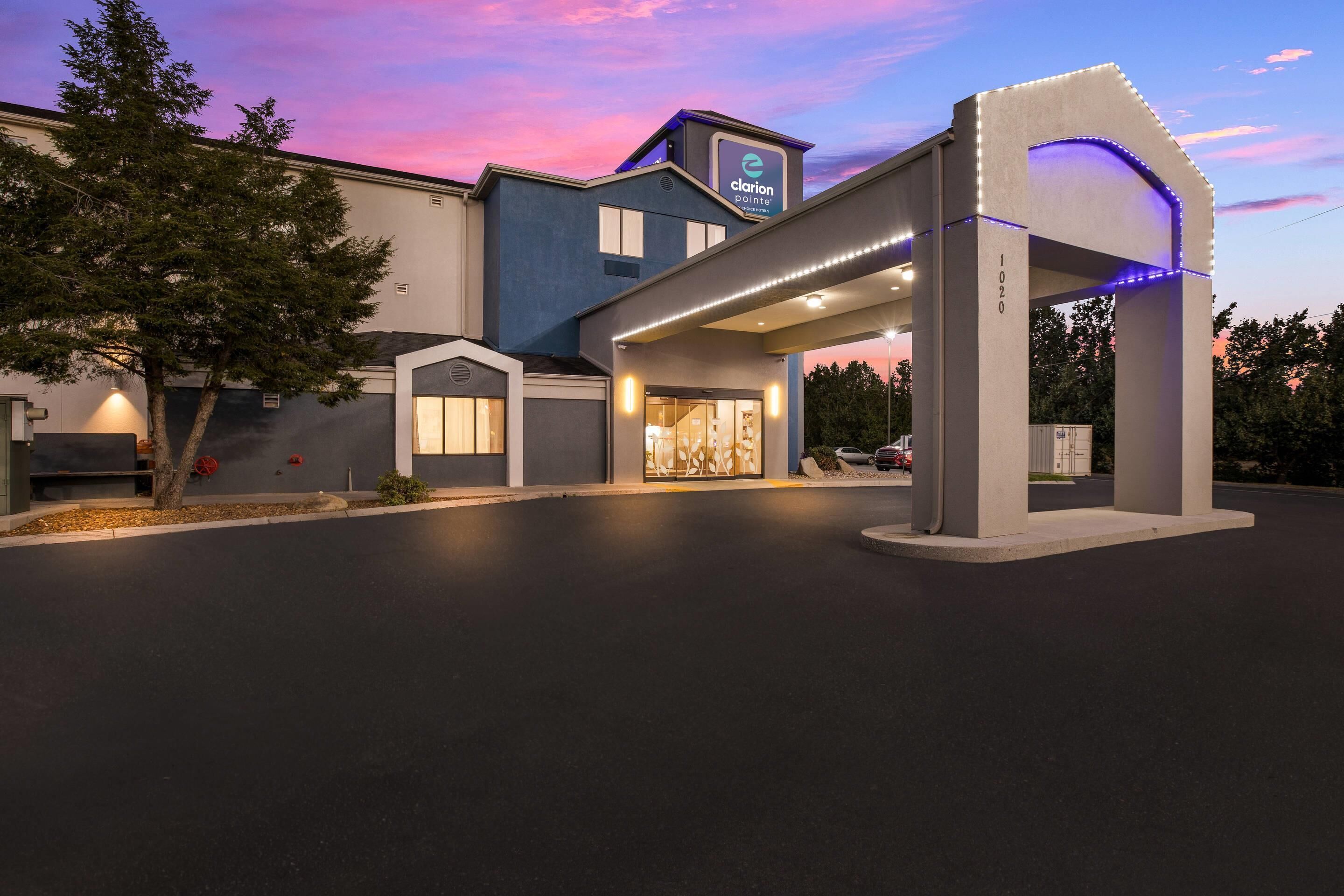 Een hotelentree met een modern ontwerp, inclusief een overdekte doorgang en een bord met Clarion Pointe.
