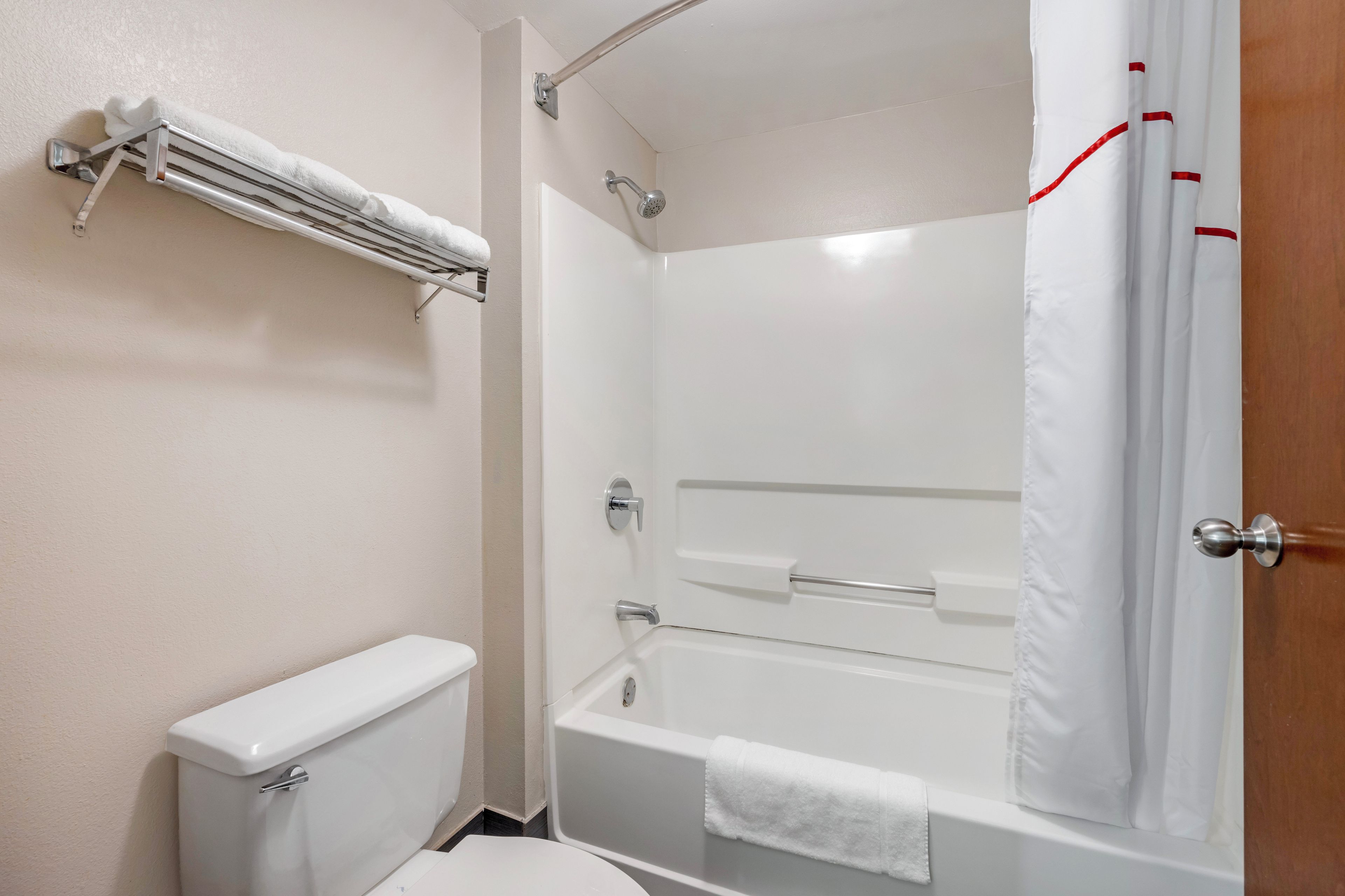 A bathroom with a toilet, a bathtub, and a shower curtain.