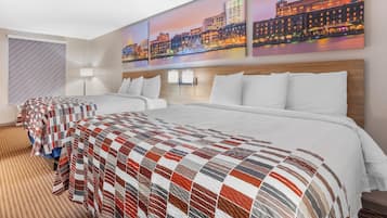 Habitación de hotel con una cama grande, una cama más pequeña y vistas a la ciudad.