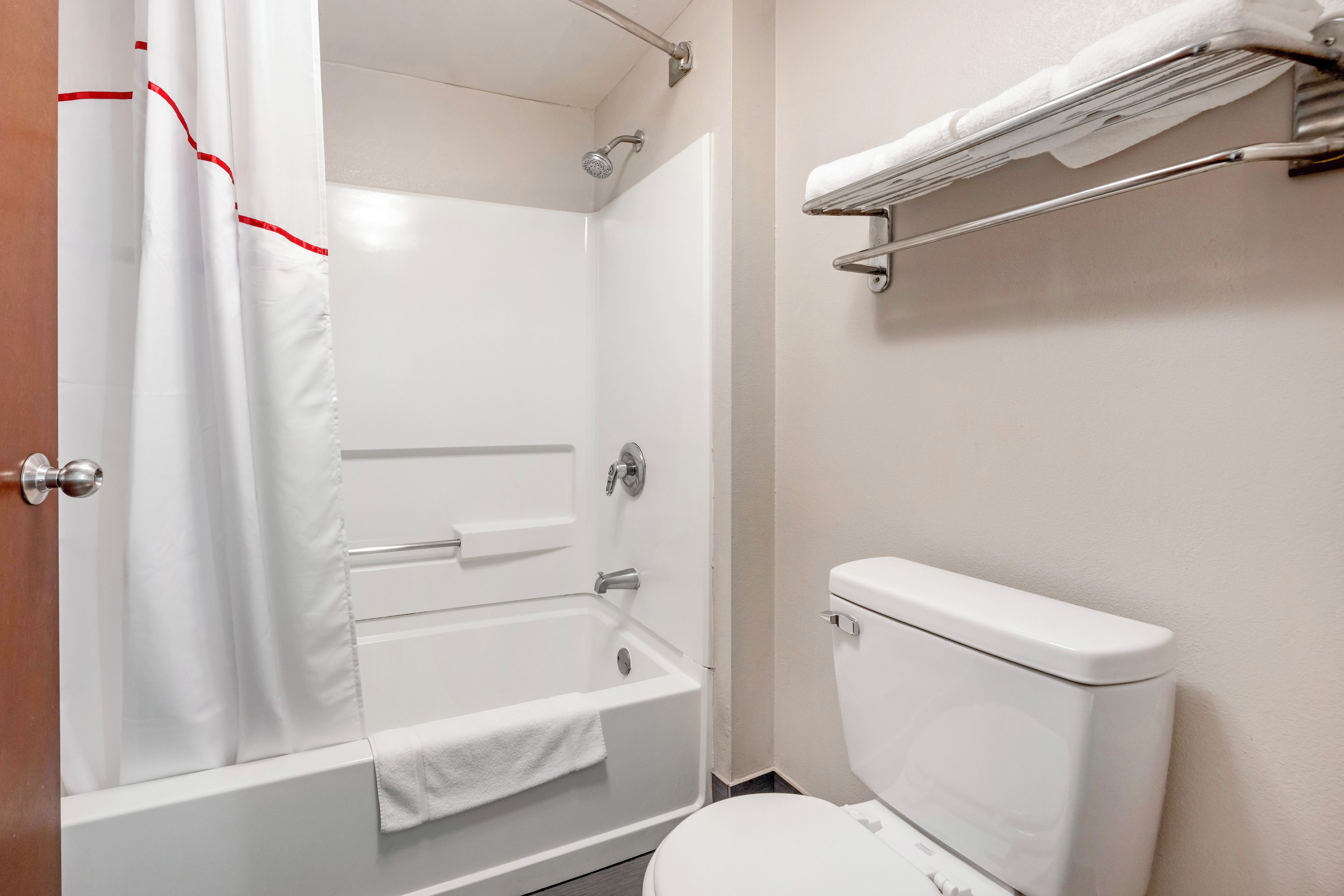 Een badkamer met een bad, toilet en een douchegordijn.