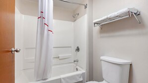 Une salle de bain avec une baignoire, des toilettes et un porte-serviettes.