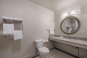 A standard hotel bathroom with a toilet, sink, mirror, towel rack, and toilet paper. - Red Roof Inn Crossville (Crossville)