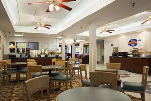 Relax in comfort with round tables and chairs, ceiling fans, and a reception desk at our hotel.