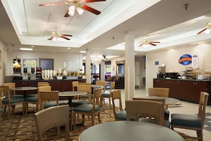 Relax in comfort with round tables and chairs, ceiling fans, and a reception desk at our hotel.