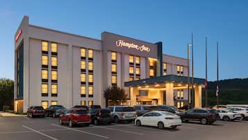 A Hampton Inn hotel with a parking lot full of cars.
