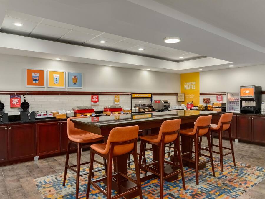 A breakfast bar with multiple seating options and a variety of food service stations.