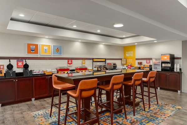 A breakfast bar with multiple seating options and a variety of food service stations.