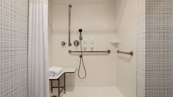 Un baño moderno con ducha a nivel, inodoro y lavabo.