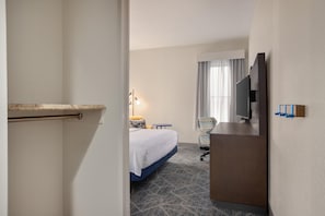 A hotel room with a bed, a desk, a chair, a television, and a minibar. - Hampton Inn Bristol (Bristol)