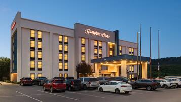 A Hampton Inn hotel with a parking lot full of cars.