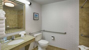 Een badkamer met een wastafel met granieten blad, een wit toilet, een handdroger en een handdoekhouder.