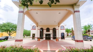 A hotel entrance with a covered walkway, brick columns, and a tiled entrance. - Best Western Pearland Inn (Pearland)