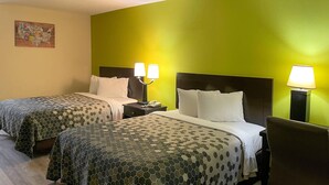 A hotel room with two beds, each with a patterned bedspread, a nightstand with a lamp, and a wall map. - Econo Lodge Inn & Suites Sweetwater I-20 (Sweetwater)