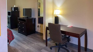 A hotel room with a wooden desk, a chair, a television, a dresser, and a mirror. - Econo Lodge Inn & Suites Sweetwater I-20 (Sweetwater)