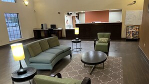A lobby with a sofa, chairs, a table, and a reception desk. - Americas Best Value Inn Pharr (Pharr)