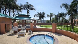 A pool area with a hot tub, lounge chairs, and a covered seating area. - Americas Best Value Inn Pharr (Pharr)