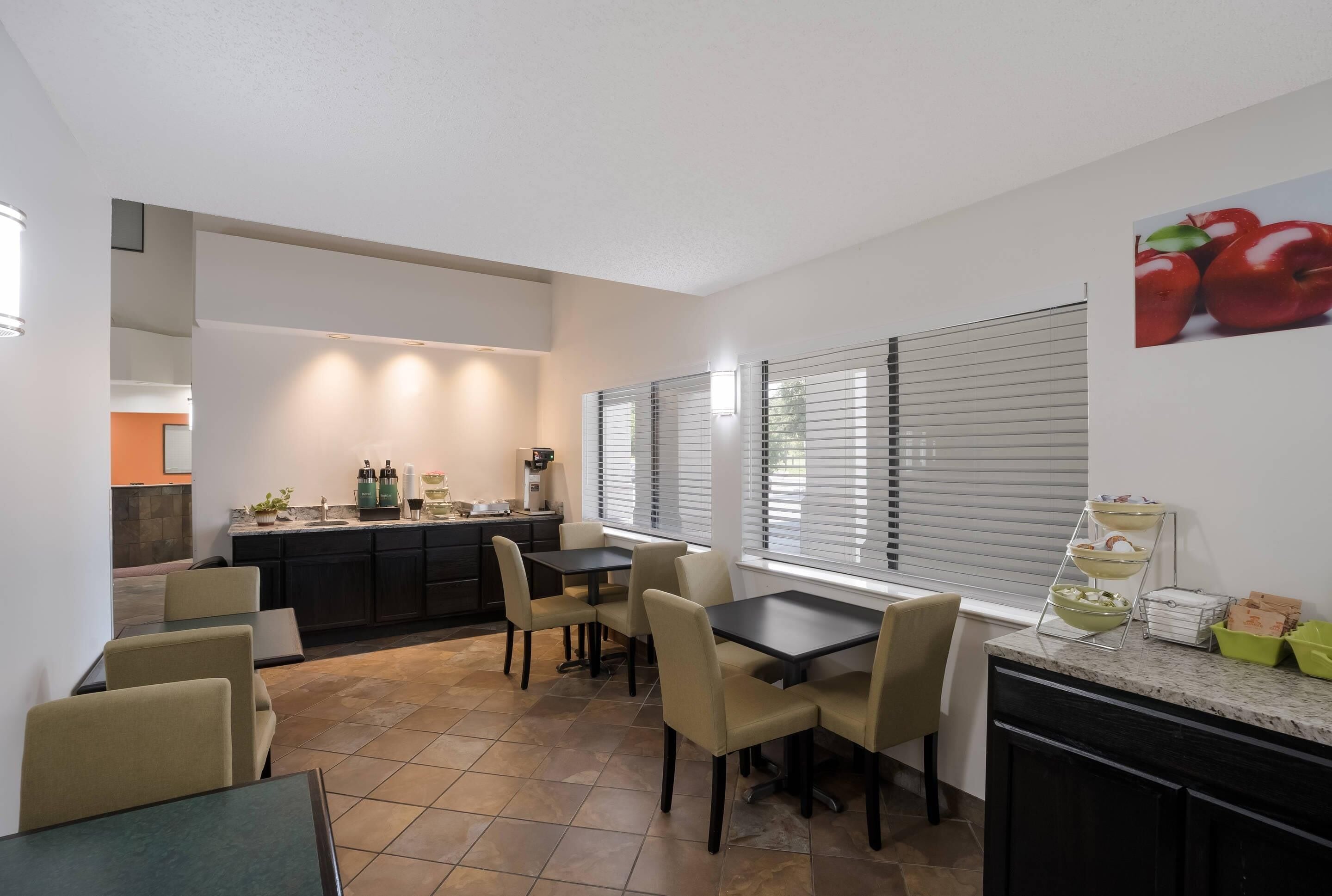 Una cocina moderna con comedor, que incluye una isla de cocina, electrodomésticos integrados y una mesa de comedor con sillas.