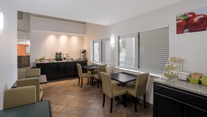 A modern kitchen with a dining area, featuring a kitchen island, built-in appliances, and a dining table with chairs.