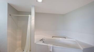 Een badkamer met een douchecabine, een bad en een plafondlamp.