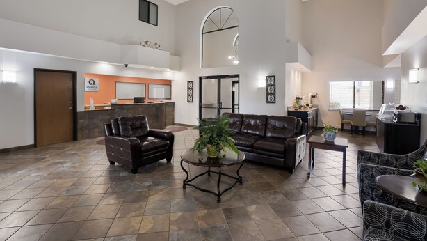 A spacious lobby with leather sofas, a coffee table, and a reception desk.