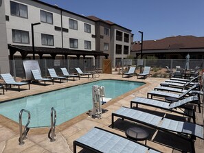 Una piscina al aire libre, sillones reclinables de piscina