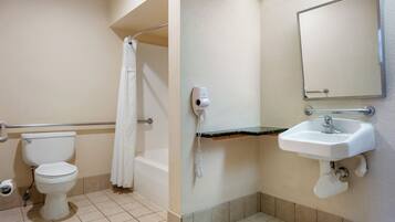 A bathroom with a toilet, a shower with a curtain, a sink with a mirror, and a hairdryer on the wall.