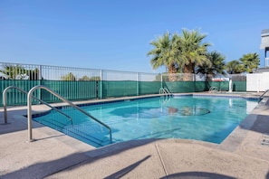 A rectangular swimming pool with a green fence and metal handrails. - Best Western Anthony/West El Paso (Anthony)