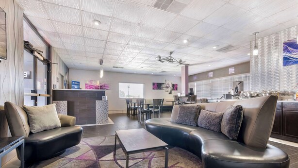 A modern hotel lobby with leather sofas, a coffee table, and a patterned rug. - Best Western Santa Fe (Amarillo)
