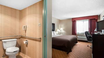 Ett hotellrum med toalett, säng, skrivbord och stol.