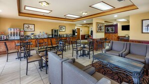 A hotel lobby with a bar area, seating arrangements, and artwork on the walls. - Best Western Lindale Inn (Lindale)