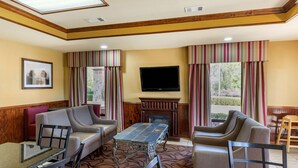 A hotel lobby with a fireplace, a flat-screen TV, and a seating area with sofas and chairs. - Best Western Lindale Inn (Lindale)