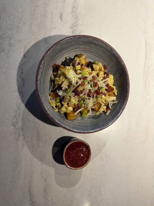 A bowl of food with a small container of sauce. - Courtyard by Marriott Lubbock (Lubbock)