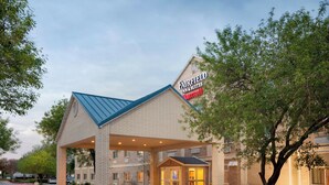 A Fairfield Inn & Suites hotel with a brick facade, a blue roof, and a covered entrance. - Fairfield Inn & Suites by Marriott® Dallas Plano West (Plano)