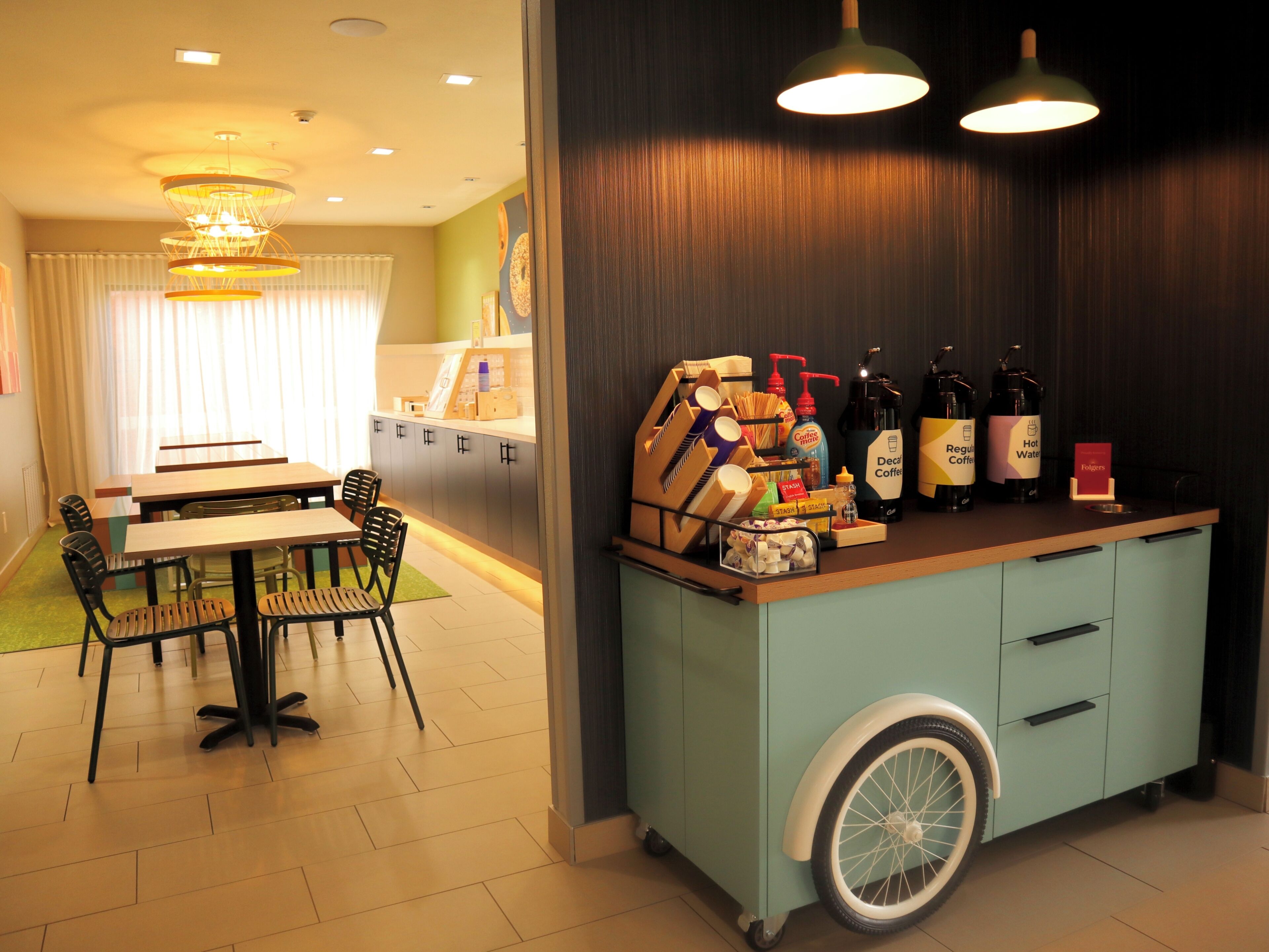 A dining area with a table and chairs, a kitchenette with a counter, and a wheelchair-accessible cabinet.